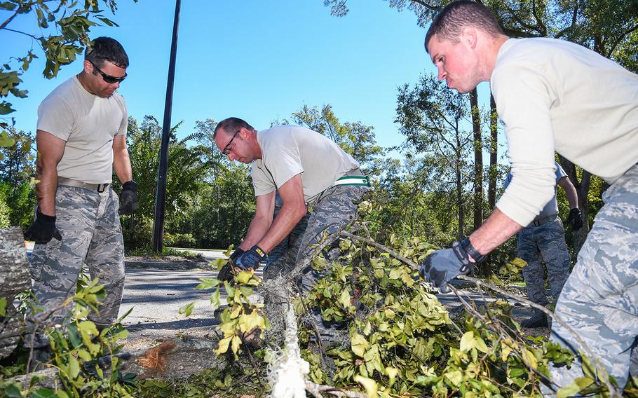 Airmen from the 116th Air Control Wing, Georgia Air National Guard, clear a tree out of a roadway during road-clearing operations in the aftermath of Hurricane Matthew, in Savannah, Ga., Oct. 10, 2016. The Airmen deployed to Savannah to support civil authorities working along side the Chatham County Public Works department.