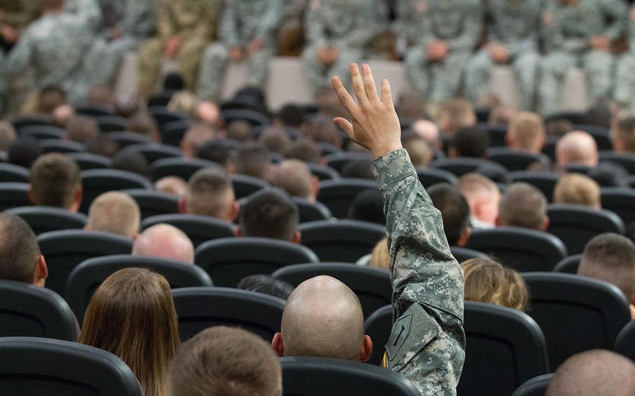 A soldier from the 1st Infantry Division raises his hand to ask a question of Sergeant Major of the Army Daniel A. Dailey on July 8, 2015 in the Barlow Theater at Fort Riley, Kansas.