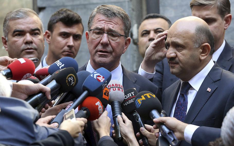 U.S Secretary of Defense Ash Carter, center, speaks to the media after he left flowers near the damaged section of the Turkish parliament bombed during the July 15 failed coup, in Ankara, Turkey, Friday, Oct. 21, 2016.