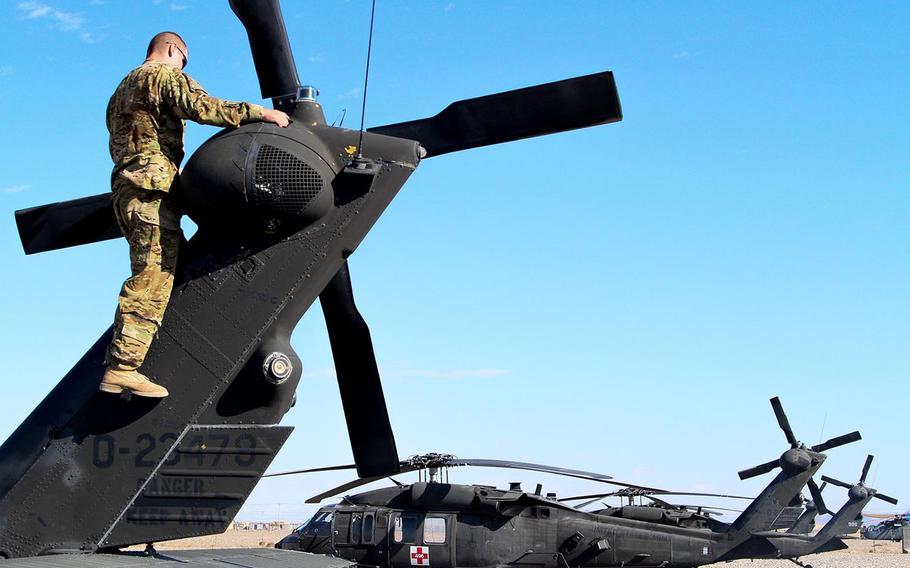 In a December, 2013 file photo, a UH-60 Black Hawk pilot with Company C, 1st Battalion, 168th Aviation Regiment, California National Guard, inspects the blades of his Black Hawk at Shindand Air Base, Afghanistan.