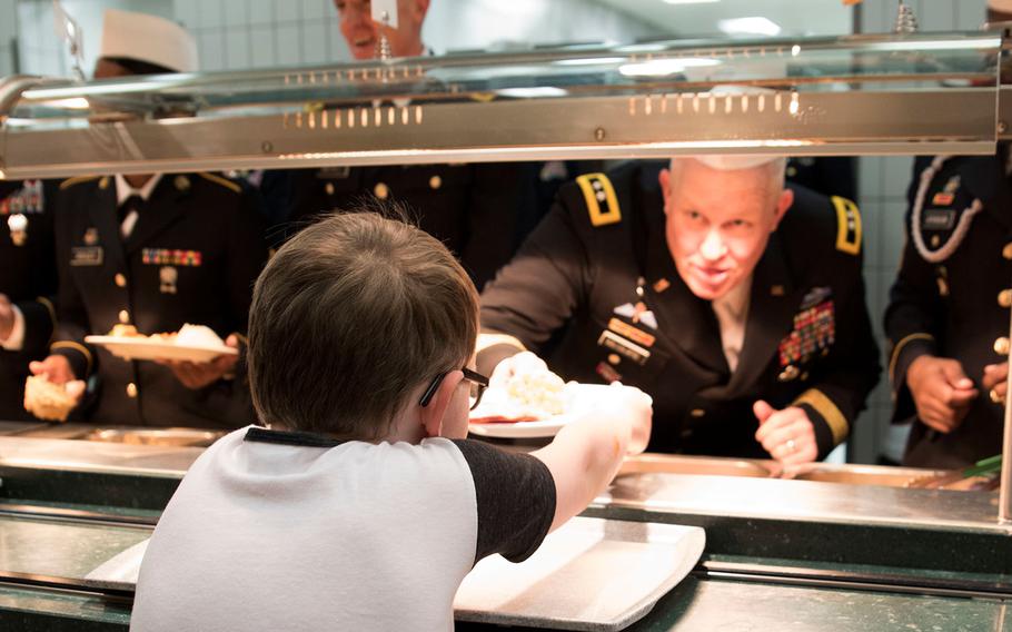 U.S. Army Europe Command Deputy Commander Maj. Gen. Timothy McGuire serves up Thanksgiving dinner to the diners at the Strong Europe Cafe in Wiesbaden, Germany on Nov. 24, 2016.