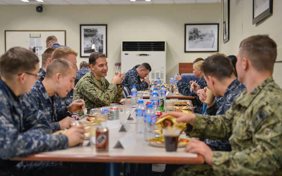 Rear Adm. Brad Cooper, the commander of U.S. Naval Forces Korea eats a Thanksgiving meal after serving sailors and Marines stationed in Pohang, Republic of Korea on Nov. 24, 2016.