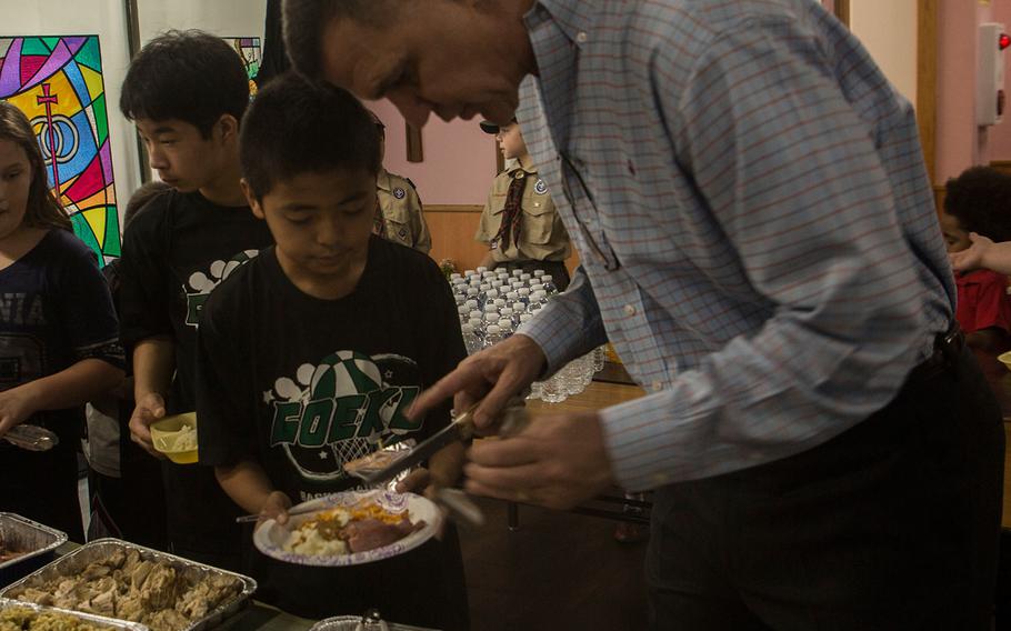 Brig. Gen. John M. Jansen serves a meal to local Okinawan children at Yugafu Church as part of the Two Fishes Project, Nov. 23, 2016. The Two Fishes Project feeds children in poverty, providing them with meals so they can focus on their school studies. U.S. Marines and sailors with 3d Marine Expeditionary Brigade shared a traditional Thanksgiving meal with these children. Jansen is the commanding general of 3d MEB. 