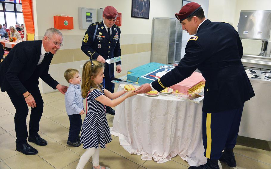 U.S. Army paratroopers assigned to the 173rd Airborne Brigade serve cake to children during the Thanksgiving lunch celebration at Caserma Del Din in Vicenza, Italy on Nov. 22, 2016.