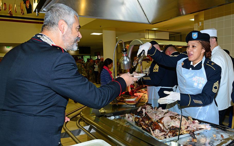 U.S. Army Master Sgt. Nicola M. Felder, assigned to U.S. Army Africa, serves lunch to Capt. Francesco Provvidenza, company commander Carabinieri Southern European Task Force, during the Thanksgiving lunch celebration at Caserma Del Din in Vicenza, Italy Nov. 22, 2016.
