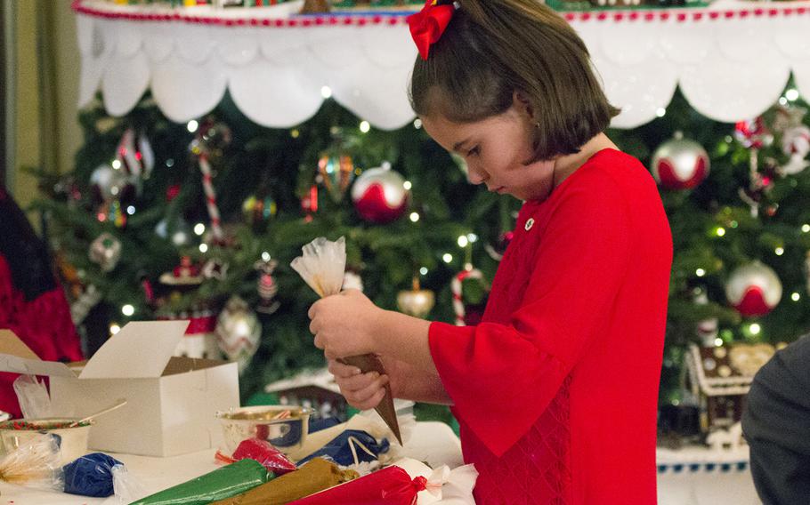 A girl decorates a cookie at the White House on Nov. 29, 2016. First Lady Michelle Obama invited military families to the White House to preview holiday decorations.