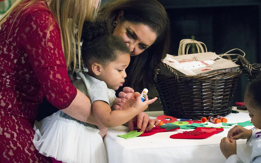 Volunteers help Ella Gatlin, the daughter of Army Lt. Col. Tim Gatlin, decorate a stocking at the White House on Nov. 29, 2016. First Lady Michelle Obama invited military families to the White House to preview holiday decorations.