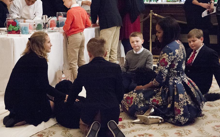First Lady Michelle Obama chats with children as they pet first dogs Sunny and Bo at the White House on Nov. 29, 2016. Obama invited military families to the White House to preview holiday decorations.