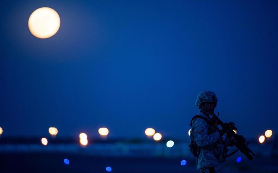 A member of the 380th Air Expeditionary Wing security forces stands on a flightline near a guard tower at an undisclosed location in Southwest Asia Nov. 14, 2016.