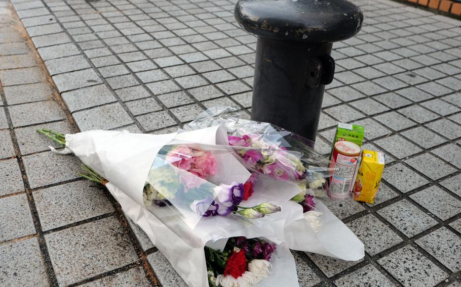Flowers and snacks are left as a memorial at the site of a  deadly crash that left three people dead and two children seriously injured. The crash occurred Saturday, Dec. 31, 2016 at a parking garage across the street from Yokosuka Naval Base. 