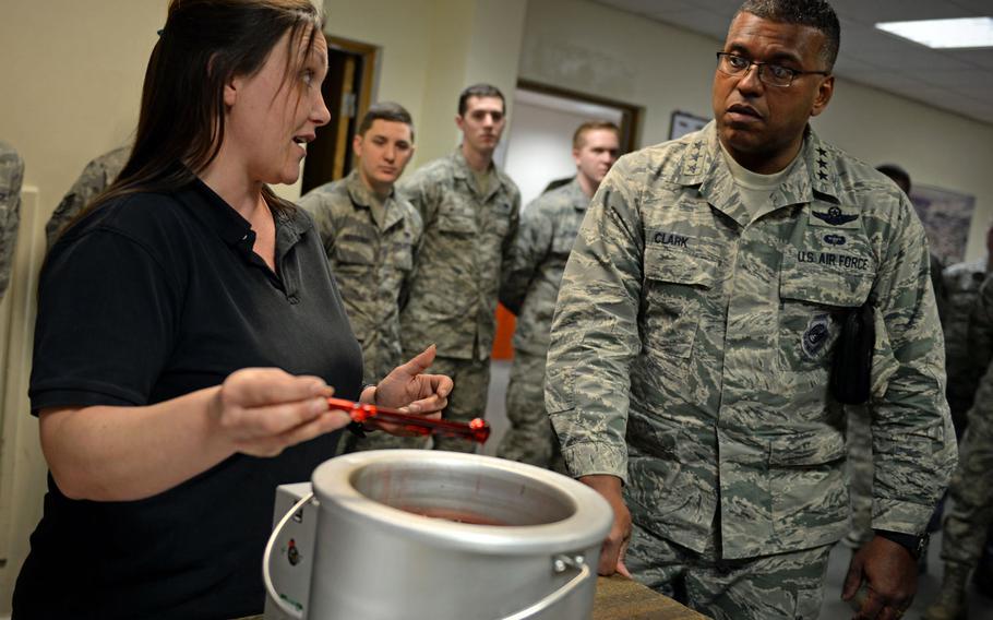 Mia Tobitt, 100th Maintenance Squadron isochronal inspection support section chief, left, demonstrates and explains the process of covering tools with a protective plastic coating to U.S. Air Force Lt. Gen. Richard Clark, 3rd Air Force commander, at RAF Mildenhall, England, Jan. 5, 2016. 