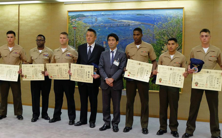 Yokosuka Mayor Yuto Yoshida poses for a photo with six servicemembers and one Japanese local who were recognized Jan. 16, 2017 for providing assistance to the victims of a deadly car crash Dec. 31, 2016.