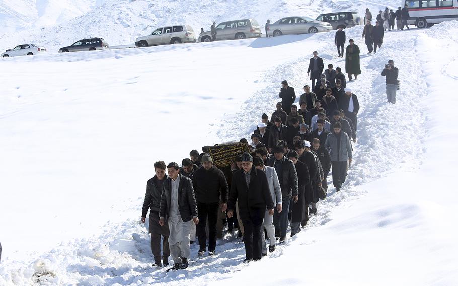 Men carry the coffin of a relative who died in a suicide attack on the Supreme Court in Kabul, Afghanistan, Wednesday, Feb. 8, 2017. 
