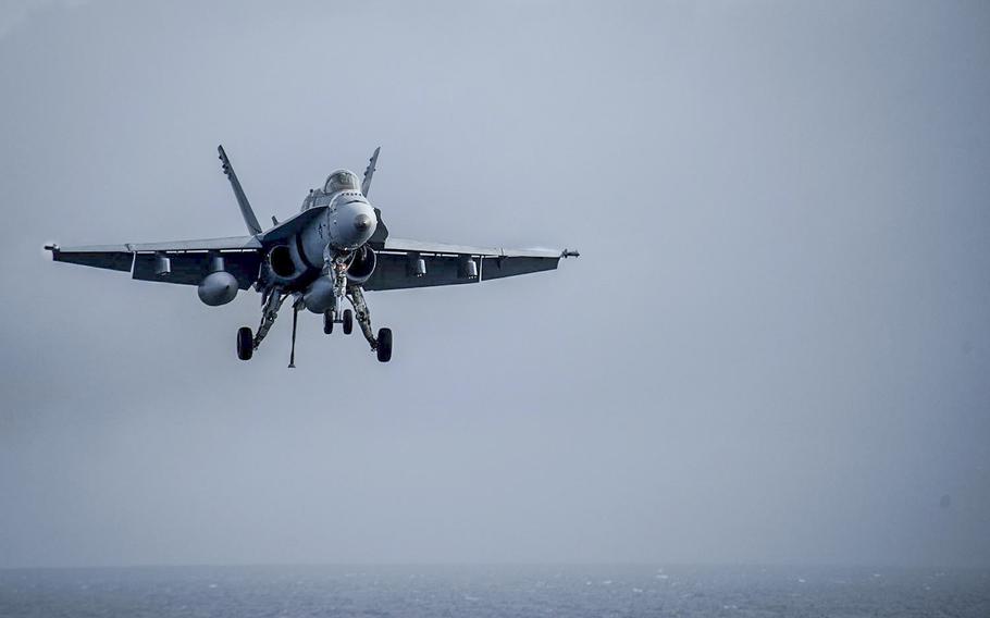 An F/A-18C Hornet, assigned to the Checkerboards of Marine Strike Fighter Squadron 312, makes its approach for landing on the flight deck of the aircraft carrier USS Theodore Roosevelt on Jan. 19, 2017. The Theodore Roosevelt is off the coast of California conducting carrier qualifications.