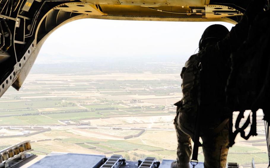 A U.S. Army soldier looks out the back of a CH-47 Chinook while flying over Afghanistan. U.S. officials say Russia is undermining NATO’s Afghan mission.