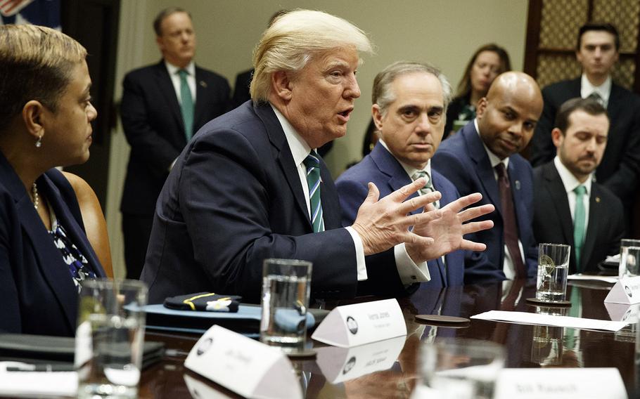 President Donald Trump, accompanied by Veterans Affairs Secretary David Shulkin, speaks during a meeting about veterans affairs, Friday, March 17, 2017, in the Roosevelt Room of the White House.