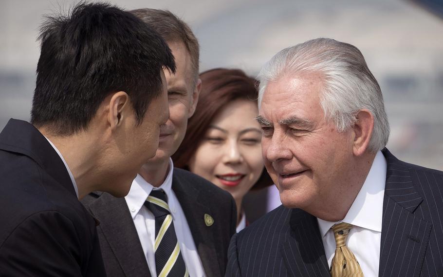 U.S. Secretary of State Rex Tillerson, right, is greeted by officials as he arrives at Beijing Capital International Airport in Beijing, China, Saturday, March 18, 2017.