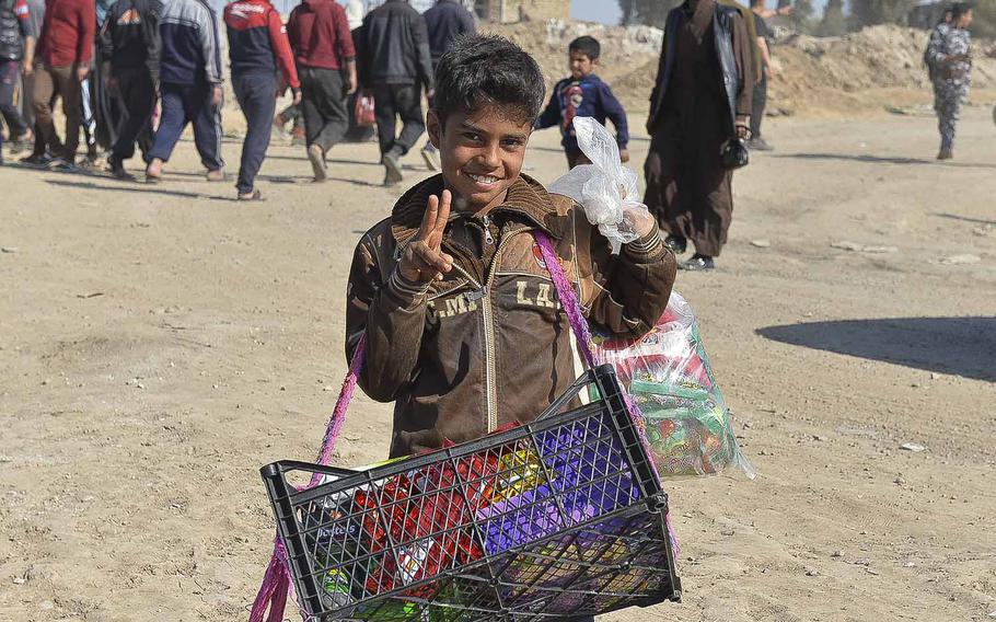 An Iraqi boy flashes a peace sign while selling chips outside a displacement camp in Hama Alil on Thursday, March 9, 2017. Thousands of Iraqis are fleeing Mosul daily as government forces battle Islamic State fighters for control of the city's western districts. The Iraqis declared the half of the city east of the Tigris River liberated in late January.
