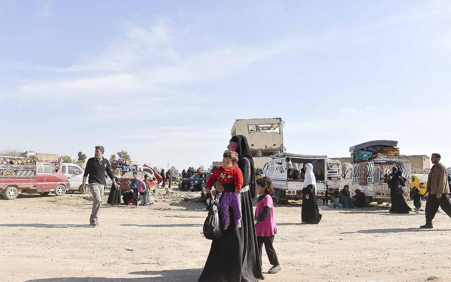 An Iraqi woman carries a child outside a camp for the displaced residents of Mosul on Thursday, March 9, 2017. 
