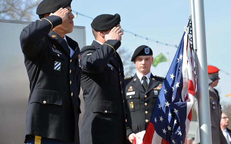 Sgt. Gabriel Cruz, left, Spc. Colton Stopp salute during the playing of the German national anthem, as Spc. James Hickman holds the American flag before its raising during the the dedication ceremony for the Rhine River crossing monument in Nierstein, Germany, Saturday, March 25, 2017. Cruz and Stopp are with the 66th Military Intelligence Brigade, while Hickman is assigned to 1st Battalion, 214th Aviation Regiment.

