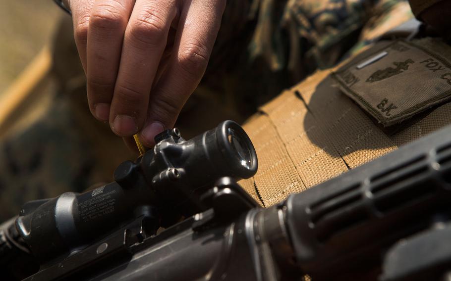 A U.S. Marine with II Marine Headquarters Group adjusts the optics on his M4 during a combat military training shoot on Camp Lejeune, N.C., March 21, 2017.