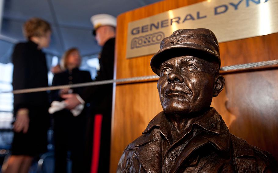 A statue of Lt. Gen. Lewis "Chesty" Burwell Puller sits as Commandant of the Marine Corps Gen. Joseph F. Dunford Jr., back center, talks with Martha Puller Downs, second left, and Janice Brinkley during the USNS Lewis B. Puller (MLP 3 AFSB) christening ceremony at San Diego, Calif., Feb. 7, 2015.