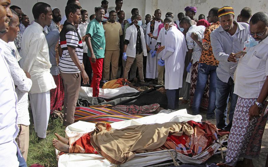 Somalis observe bodies which were brought to and displayed in the capital Mogadishu, Somalia Friday, Aug. 25, 2017.