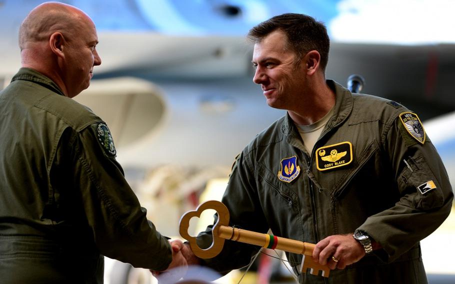 U.S. Air Force Lt. Col. Cody Blake, 493rd Expeditionary Fighter Squadron detachment commander, accepts the key to the Baltic Air Policing mission from Polish air force Lt. Col. Piotr Ostrouch during the official Baltic Air Policing hand-over, take-over ceremony at Siauliai Air Base, Lithuania, Aug. 30, 2017.
