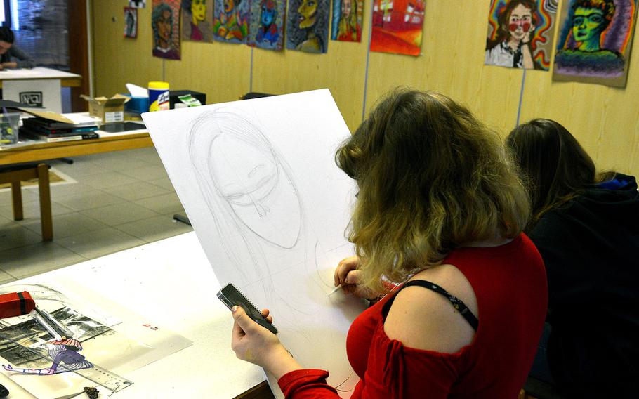 Wiesbaden's Regan Donofrio works on a piece in the drawing workshop at DODEA-Europe's Creative Connections, Wednesday, Nov. 1, 2017. Finished works hang on the wall in the background.

