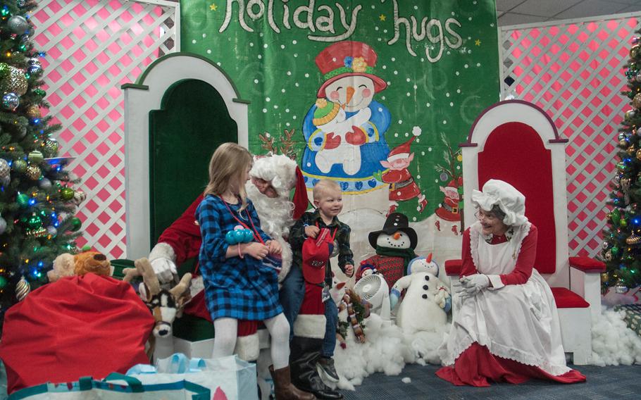 Three year old James Anthony Lindh III, nicknamed Tripp, and his sister Penelope, 4, sit with Santa after flying United Airlines' Fantasy Flight to the "North Pole" at Washington-Dulles International Airport in Virginia on Saturday, Dec. 9, 2017.