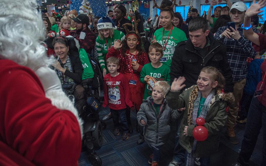 After deplaning from United Airlines' Fantasy Flight to the "North Pole," passengers greet Santa Claus at Washington-Dulles International Airport in Virginia on Saturday, Dec. 9, 2017. Ann Armstrong-Daley, founder of Children’s Hospice International seen in a wheelchair at far left, said it’s the help from hundreds of volunteers that makes the event come alive.