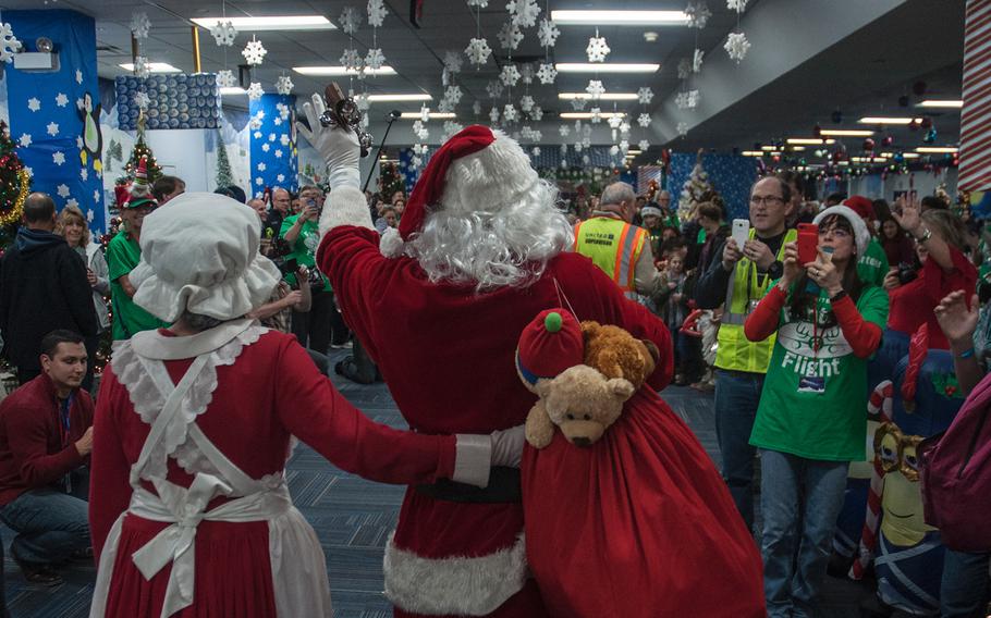 Mr. and Mrs. Santa Claus greet passengers from United Airlines' Fantasy Flight after deplaning at the "North Pole" at Washington-Dulles International Airport in Virginia on Saturday, Dec. 9, 2017.