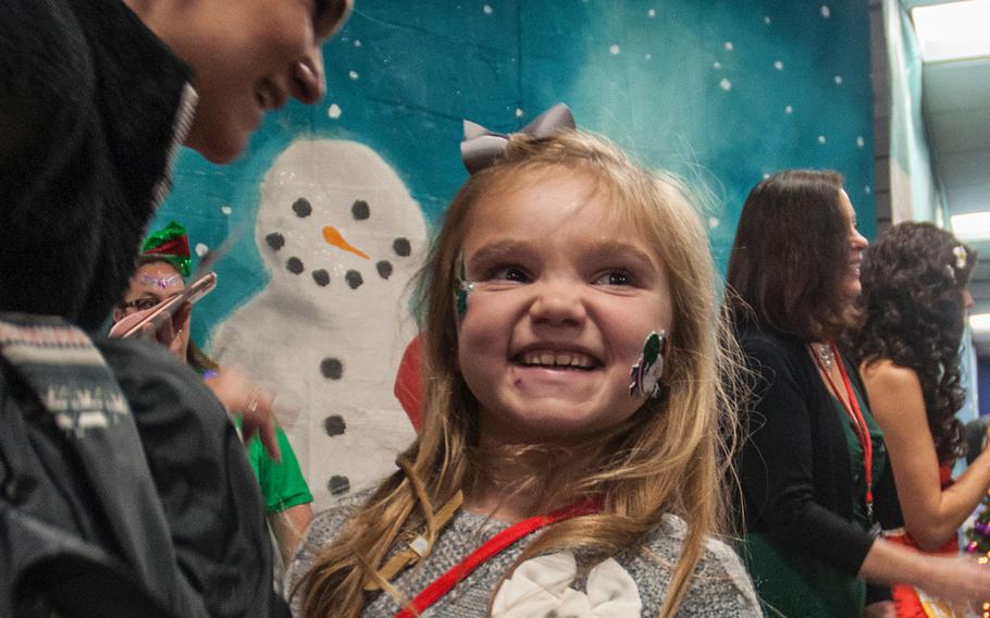 A girl smiles with delight as she and her family arrive at the "North Pole" after deplaning from United Airlines Fantasy Flight at Washington-Dulles International Airport in Virginia on Saturday, Dec. 9, 2017.