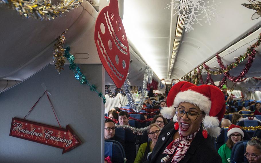 Teresa Little, a United Airlines flight attendant and self-proclaimed "Santa's Helper,"   dashes through the cabin as she leads Fantasy Flight passengers in a spirited sing-a-long of "Jingle Bells" prior to takeoff at Washington-Dulles International Airport in Virginia on Saturday, Dec. 9, 2017.