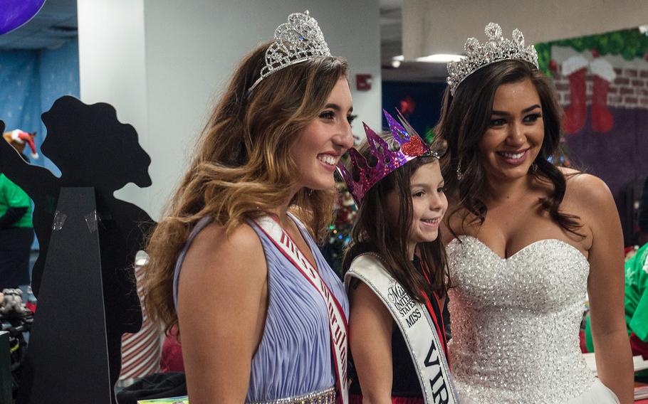 After deplaning from United Airlines' Fantasy Flight to the "North Pole," Madelyn Gillingham, 6, stands with the 2017 Miss Teen Maryland, Trudye Lutton, 19, left, and the 2016 Miss Virginia, Kelly Seibold, 23, at Washington-Dulles International Airport in Virginia on Saturday, Dec. 9, 2017.