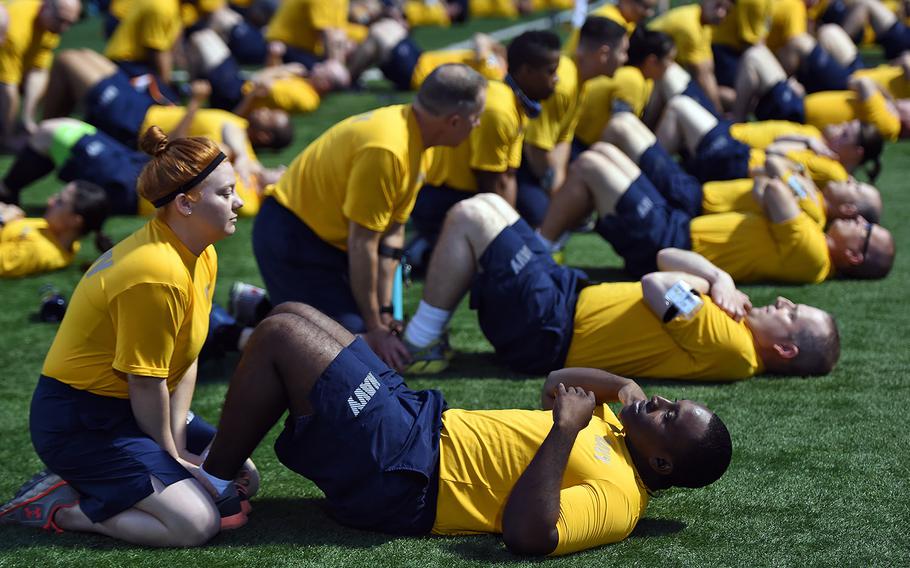 Sailors assigned to Combined Joint Task Force-Horn of Africa prepare to perform two minutes of curl-ups during a practice physical fitness test at Camp Lemonnier, Djibouti, Feb. 24, 2017. The trial assessment gave Sailors an opportunity to test their physical readiness prior to the April implementation of the Navy Physical Fitness Assessment program.