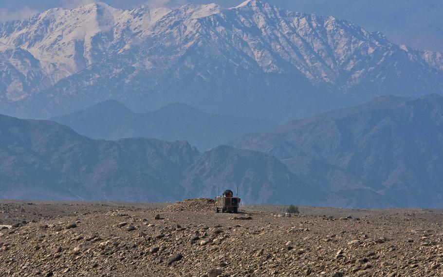 In a 2011 file photo, the mountains of Tora Bora loom over a lone U.S. mine resistant ambush protected vehicle as it patrols outside the Achin District Center.
