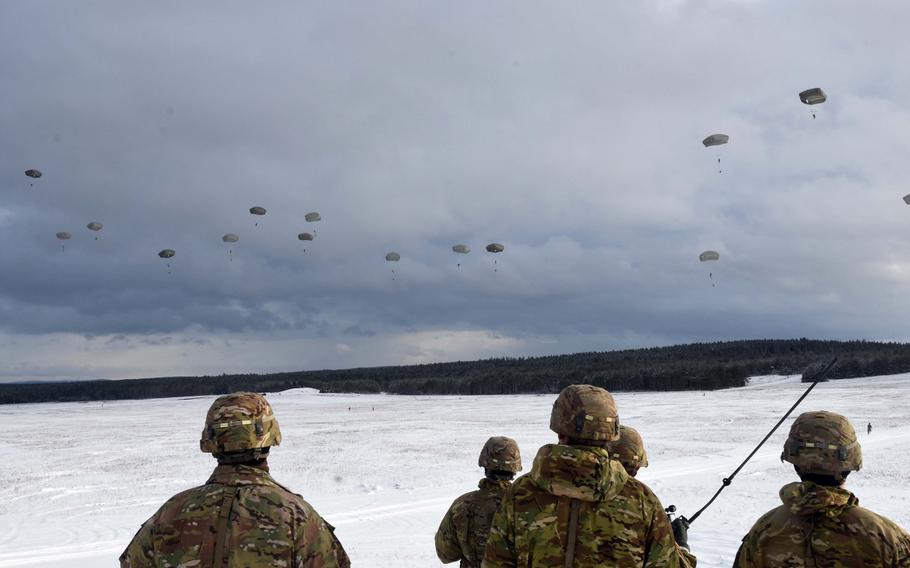 Soldiers with the 173rd Brigade Combat Team (Airborne) watch as fellow soldiers parachute to the ground during an exercise at Grafenwoehr, Germany, on Wednesday, Jan. 17, 2018. 