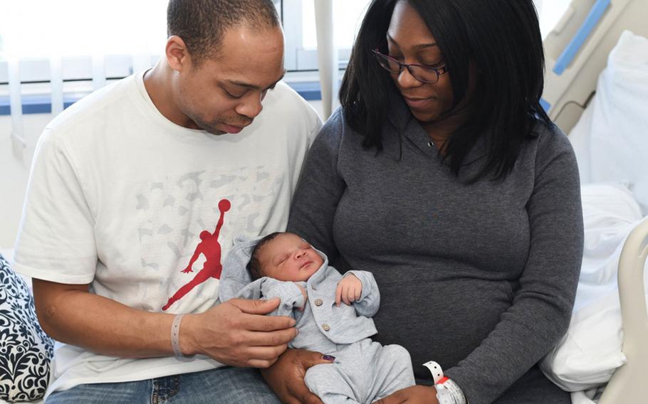 Brittney Clark (right) and her husband, Chief Electronics Technician Byron Clark, pose with their newborn son Amir in the Maternal Infant Unit (MIU) at U.S. Naval Hospital (USNH) Yokosuka. Amir is the first baby of 2018 born in the facility. The Navy is recommending the amount of non-chargeable leave for secondary caregivers to increase to 21 days in the event of a birth or adoption.