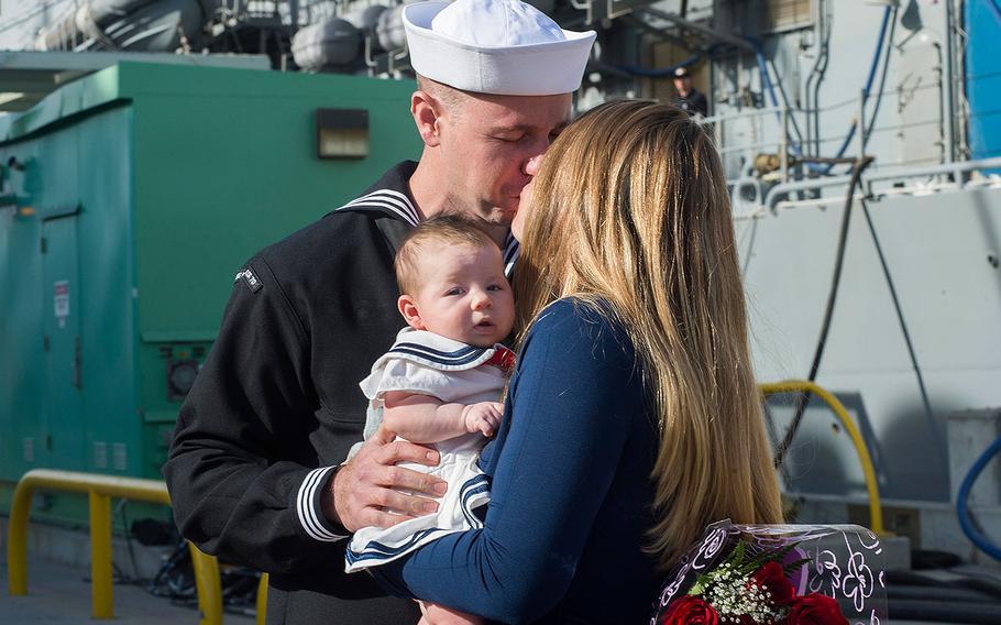 Petty Officer 1st Class Austin Emery, assigned to the USS Lake Erie, greets his wife and newborn daughter after the ship returned to Naval Base San Diego after a 7-month deployment on Dec. 10, 2017.