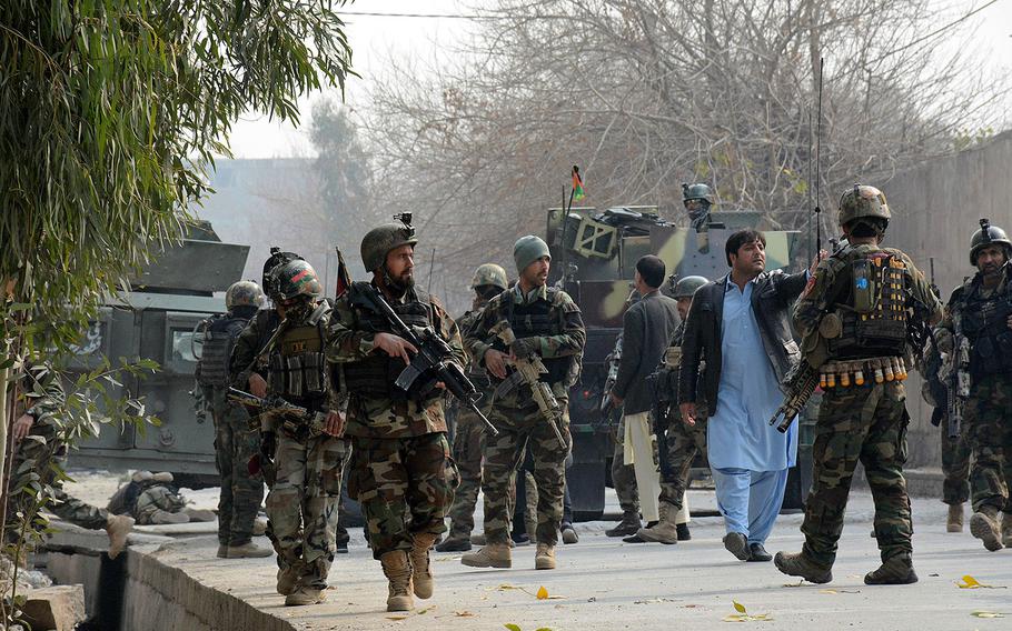 Uniformed and plainclothed Afghan security forces patrol the site of a deadly suicide attack in Jalalabad, east of Kabul, Afghanistan, Wednesday, Jan. 24, 2018.