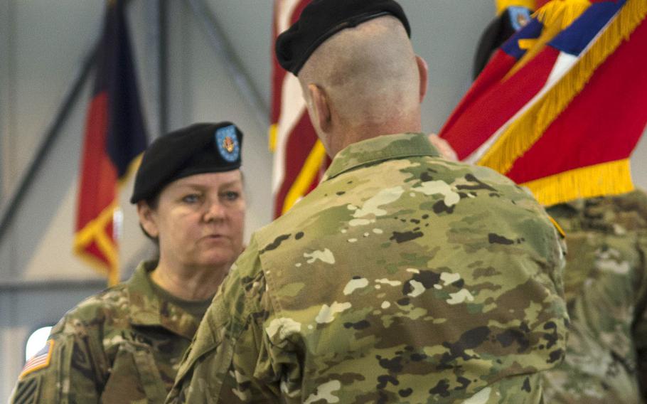 Command Sgt. Maj. Sheryl Lyon, left, passes the U.S. Army Europe colors to Lt. Gen. Christopher Cavoli, USAREUR commander, during her relinquishment of responsibility ceremony Tuesday, Feb. 20, 2018 in Wiesbaden, Germany. Lyon, who has an intelligence background, will next be taking responsibility at U.S. Army Cyber Command at Fort Belvoir, Va. 
                