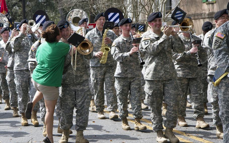 A member of the 3rd Infantry Division Band gets kissed by a spectator during a previous parade.