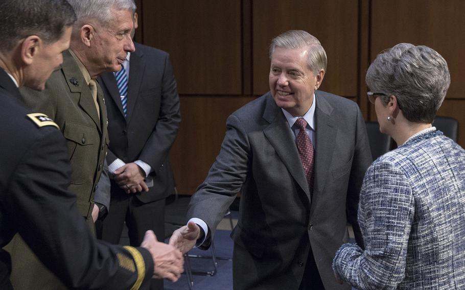 Gen. Joseph L. Votel, commander of the U.S. Central Command, shakes hands with Sen. Lindsey Graham, R-S.C., as Gen. Thomas D. Waldhauser, commander of the U.S. Africa Command, and Sen. Joni Ernst, R-Iowa, watch before a Senate Armed Services Committee hearing on Capitol Hill, March 13, 2018.