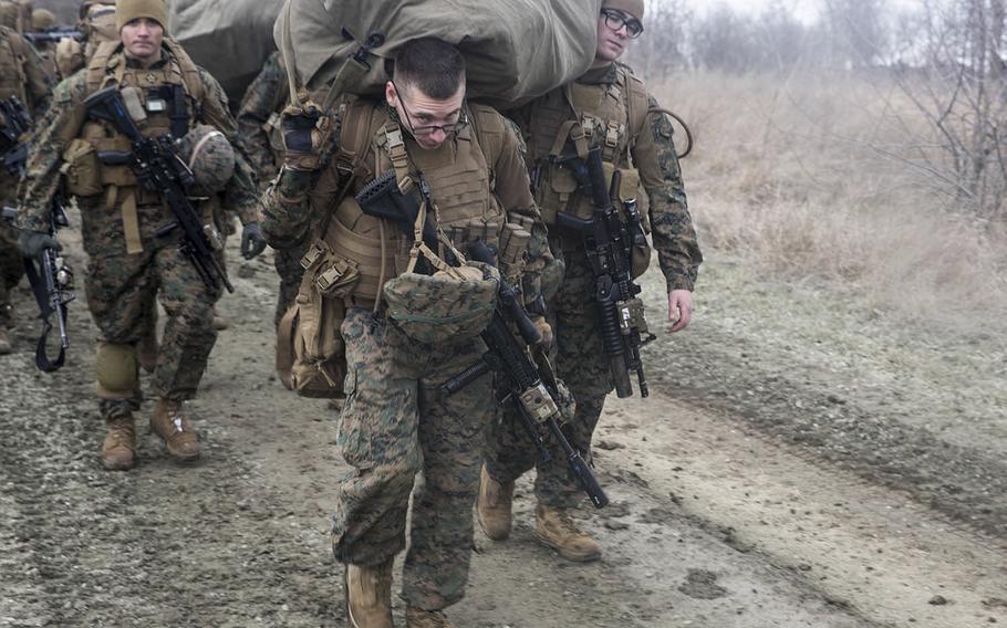 A team from the 26th Marine Expeditionary Unit carries equipment and weapons to the barracks at the Capu Midia training area in Romania on March 9, 2018 during the Spring Storm exercise.