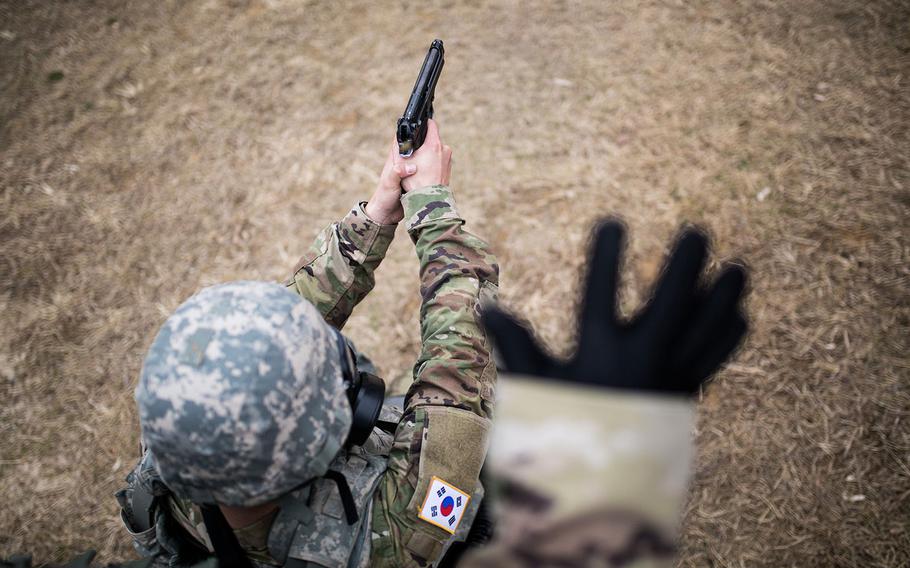 A 19th Expeditionary Sustainment Command best warrior competitor fires a pistol during a stress shoot at Masan, South Korea on Wednesday, March 7, 2018. 