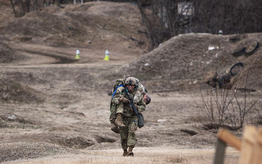 Sgt. Gerardo Saavedra, 94th Military Police Battalion, 19th Expeditionary Sustainment Command best warrior competitor carries a training dummy during a stress shoot at Masan, South Korea on Wednesday, March 7, 2018. 