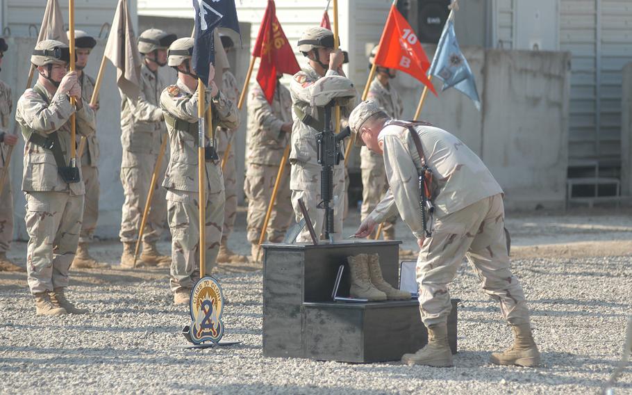 A solider lays a device on a battlefield cross erected for Spc. Dwayne McFarlane, who was killed in Iraq on Jan. 9, 2005. The nonprofit behind the effort to establish a national memorial dedicated to the Global War on Terror got a new director Monday, April 9, 2018. 