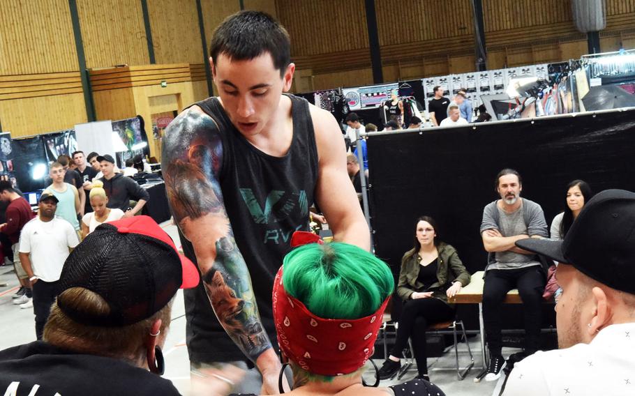 Sgt. Jared Taylor, a scout with the 2nd Cavalry Regiment, shows his new fox tattoo to the judges at the Tattoo Expo Grafenwoehr, in Grafenwoehr, Germany on Sunday, April 15, 2018. Taylor ended up winning best color tattoo.