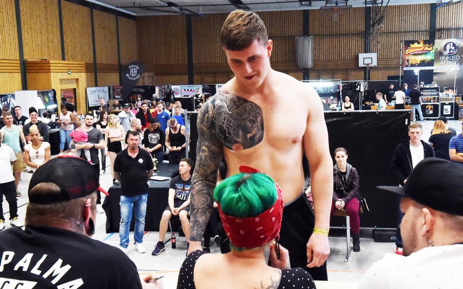 Spc. Dallas Immell, an infantry soldier with the 2nd Cavalry Regiment, shows his new tattoo of Perseus to the judges at the Tattoo Expo Grafenwoehr, in Grafenwoehr, Germany, Sunday, April 15, 2018. Immell ended up winning best overall tattoo at the expo.